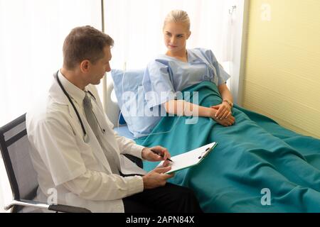 Il medico controlla e discute con il paziente in clinica o il medico parla con le donne pazienti in ospedale Foto Stock