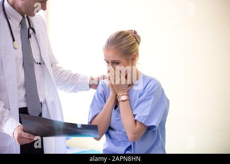 Medico che spiega i polmoni raggi X alle donne che sono pazienti in clinica o medico in ufficio che esaminano una radiografia e discutono con un paziente Foto Stock