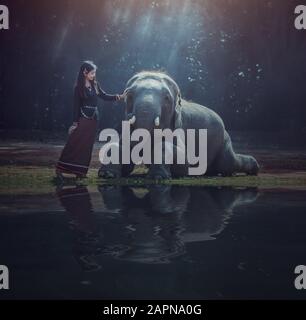 Bella donna asiatica indossa abito tailandese con il suo elefante, Surin, Campagna della Thailandia Foto Stock