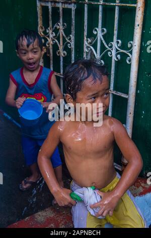 Il bambino gioca con l'acqua durante il festival Higantes ad Angono Filippine Foto Stock