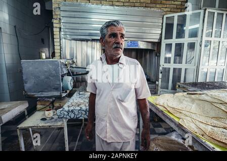 Baker uomo nel tradizionale panificio prodotte focacce a Kashan città, capitale della contea di Kashan dell'Iran Foto Stock