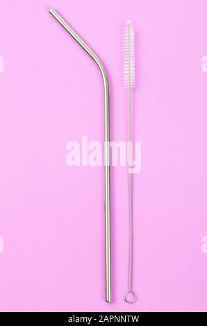 cannucce riutilizzabili in acciaio inox e spazzola di pulizia su sfondo rosa, stile di vita ecocompatibile Foto Stock