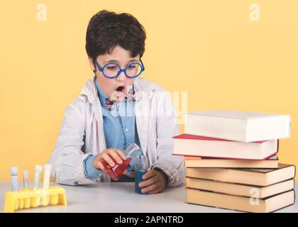 Bambino scienziato in laboratorio su sfondo giallo Foto Stock