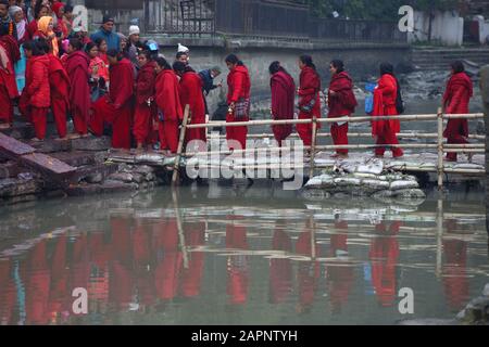 Kathmandu, Nepal. 24th Gen 2020. I devoti indù nepalesi che attraversano il fiume Bagmati durante il Festival di Narayan di Madhav o lo Swasthani Brata Katha Pashupathinath Temple a Kathmandu, Nepal, venerdì 24 gennaio 2020. I devoti vanno in pellegrinaggio a vari templi, svolgono rituali religiosi, fanno un bagno santo nei fiumi e veloci per un mese, soprattutto tra le donne che credono che il digiuno aiuti nel benessere della loro famiglia o nel farli un buon marito. (Foto Di Subash Shrestha/Pacific Press) Credit: Pacific Press Agency/Alamy Live News Foto Stock