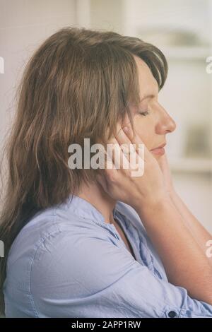 Donna pratica self Reiki con trasferimento di energia attraverso le palme, una sorta di medicina energetica. Foto Stock