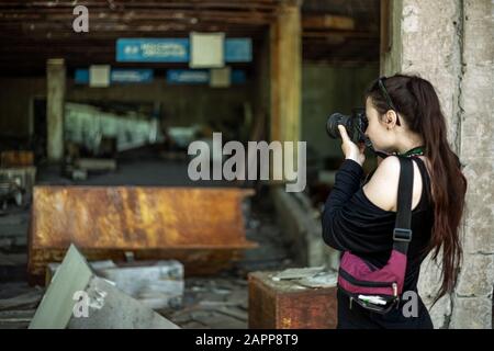 Pripyat, Ucraina, 20 Maggio 2019. Ragazza scatta le foto di un supermercato abbandonato Foto Stock