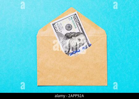 Dollari americani in una busta di posta su uno sfondo blu, vista dall'alto Foto Stock