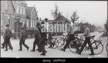 [Ragazzi con e senza bici attraversare a piedi sotto la supervisione di un cosiddetto pronto-over o poliziotto traffico] Data: Parole Chiave dense: Ragazzi, sicurezza stradale Foto Stock