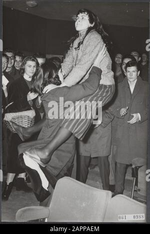 Ad Amsterdam, tre cinema suoneranno i dischi del rock 'n' roll americano re Elvis Presley nella pausa di mezzogiorno dal venerdì, come pubblicità per il film Love me tender che la prossima settimana apparirà. Sul primo centrodad c'erano un gran numero di giovani entusiasti che, a causa della musica emozionante, non hanno rimanere nei sedili per lungo e ballato il Rock and Roll tra le file. Data: 7 dicembre 1956 luogo: Amsterdam, Noord-Holland Parole Chiave: Cinema, danze, gioventù, musica Foto Stock