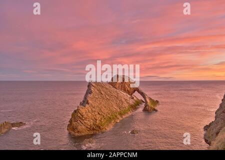 BOW FIDDLE ROCK PORTKNOCKIE MORAY FIRTH SCOTLAND GENNAIO NUBE ROSA ALBA E UN MARE CALMO Foto Stock