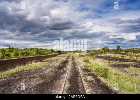 Un binario ferroviario utilizzato per l'accesso alla macchina a una torba industriale Bord na Mona tagliata via utilizzata per l'estrazione della torba vicino a Cloghan, County Offaly, Irlanda Foto Stock