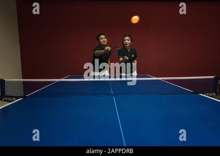 Coppie di giovani che giocano a ping pong con le pagaie da ping pong che si divertono Foto Stock