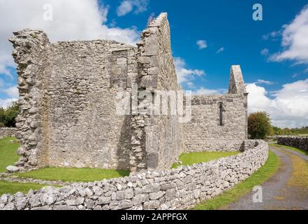 Edifici in rovina e muri in pietra costuciti da calcare Carbonifero al 7 ° secolo Kilmacduagh monastero vicino a Gort, Contea di Galway, Irlanda Foto Stock