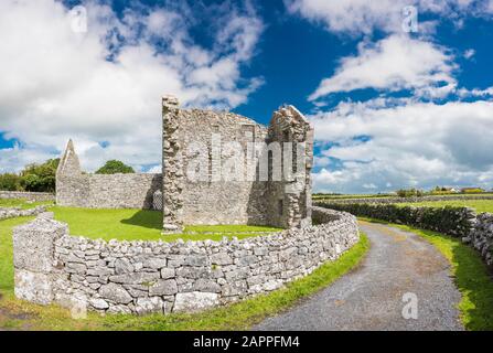 Edifici in rovina e muri in pietra costuciti da calcare Carbonifero al 7 ° secolo Kilmacduagh monastero vicino a Gort, Contea di Galway, Irlanda Foto Stock