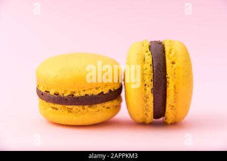 Gustosi amaretti gialli francesi su sfondo pastello rosa. Primo piano. Inserire il testo. Foto Stock