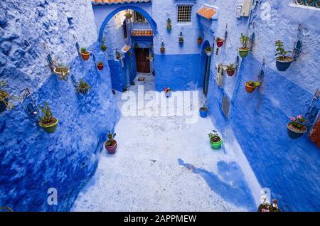 Parete blu e scala decorata con vasi colorati. Foto Stock