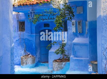 Parete blu e scala decorata con vasi colorati. Foto Stock