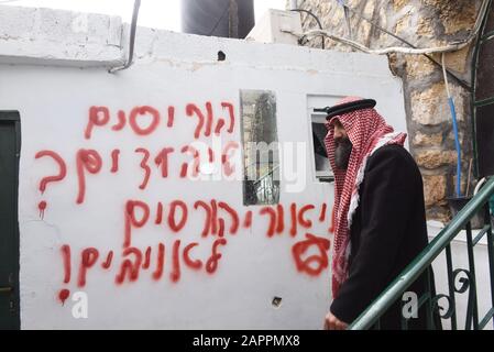 Sharafat, Israele. 24th Gen 2020. Un Palestinese guarda i graffiti nella lettura ebraica 'stanno distruggendo gli ebrei? Kumi Ori distruggerà la sinistra del nemico su un muro al di fuori di una moschea, in un sospetto attacco di odio ultranazionalista ebraico, a Sharafat, venerdì 24 gennaio 2020. Gli attaccanti hanno anche acceso una vecchia moschea nel villaggio arabo . Foto di Debbie Hill/UPI Credit: UPI/Alamy Live News Foto Stock