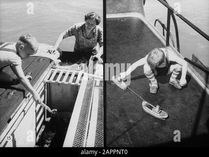 Gloria olandese sulla navigazione Reno, rapporto sulla vita e lavoro a bordo di una nave Reno. Shipperskind Wim van Geijn trasporta i polli a bordo del Damco 230 sotto l'occhio vigile di sua madre. Schipperskind Wim van Geijn giocare con le sue barche sul ponte del Damco 230 Data: 1 aprile 1955 posizione: Germania, Germania occidentale Parole Chiave: Chiatte, vita quotidiana, polli, toddlers, fiumi, giocare Nome personale: Geijn, Wim van Foto Stock