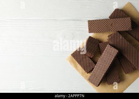 Carta artigianale con wafer su sfondo di legno bianco, vista dall'alto Foto Stock