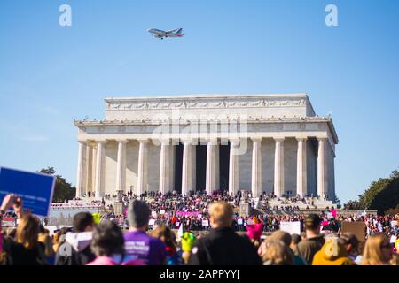 Washington, DC - 20 gennaio 2018: Gli attivisti si riuniscono di fronte al Lincoln Memorial per la marcia femminile con un aereo in volo. Foto Stock