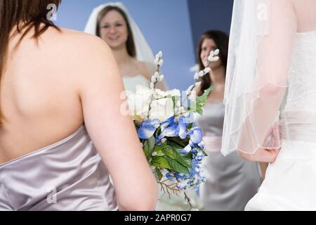 Sposa con la sua sposa che guarda in uno specchio. Foto Stock