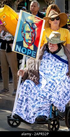 L’uomo anziano e disabile in sedia a rotelle detiene un segno di protesta anti-Trump alla marcia femminile dell’OC. Questa è stata la 4th edizione annuale della marcia femminile negli Stati Uniti. Foto Stock