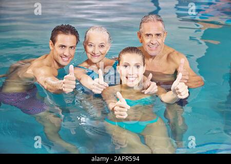 Il gruppo felice in acqua fitness in acqua tiene i pollici su Foto Stock