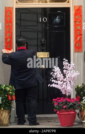 Londra, Regno Unito. 24th Gen 2020. Un uomo incolla coppie fuori 10 Downing Street a Londra, Gran Bretagna, 24 gennaio 2020, per celebrare il cinese Lunar nuovo anno. Credito: Ray Tang/Xinhua/Alamy Live News Foto Stock