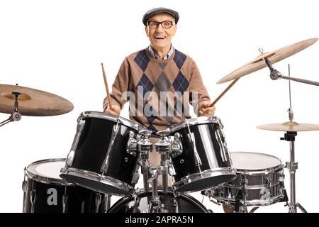 Batterista senior con un drum set sorridente alla telecamera e suonante con tamburi isolati su sfondo bianco Foto Stock