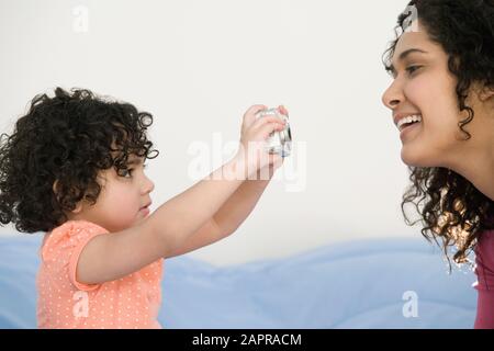 Close-up di una ragazza di scattare una foto di sua madre con una fotocamera digitale Foto Stock
