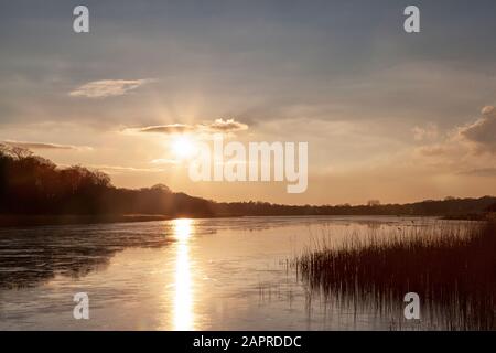 Gelido guardando il tramonto invernale ai piedi delle Eels, Ormesby. Foto Stock