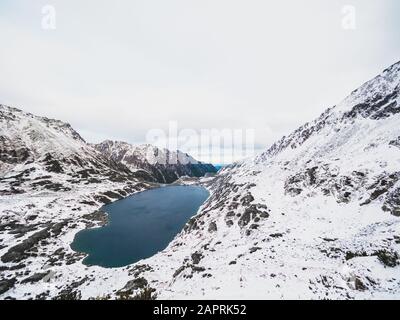 Splendido scenario di un lago circondato dai Monti Tatra Coperto di neve in Polonia Foto Stock