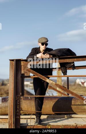Ritratto a tutta lunghezza di un uomo elegante che usa lo smartphone durante il giorno di sole Foto Stock
