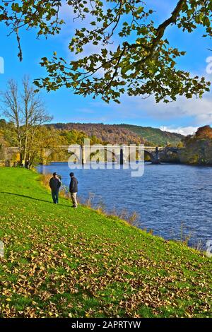 Una splendida vista autunnale del fiume Tay a Dunkeld, dove passa sotto il vecchio ponte in pietra progettato da Thomas Telford e costruito 1804-1809. Foto Stock