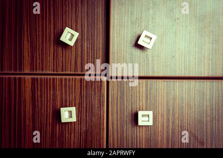 Colpo di closeup di un armadio di legno con quattro porte con maniglie quadrate piccole Foto Stock