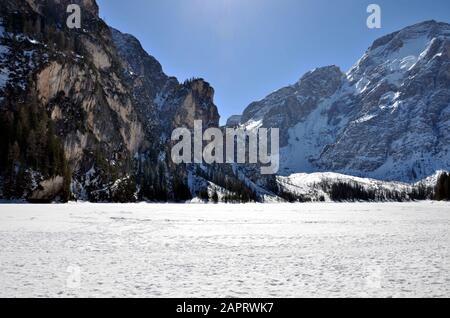 Alte pareti rocciose si affacciano sul lago ghiacciato Foto Stock