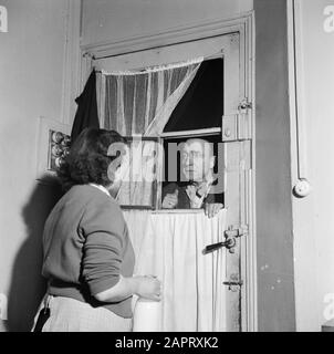 Il lavoro quotidiano di un concierge in un appartamento di Parigi un fornitore arriva alla porta Data: 1936 Località: Francia, Parigi Parole Chiave: Porte, finestre, donne Foto Stock