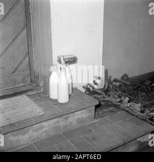 Giorno nella vita della famiglia Svendsen bottiglie di latte e pacchetti di burro stand sul marciapiede alla porta principale Data: Marzo 1954 luogo: Danimarca Parole Chiave: Burro, vita quotidiana, porte, latte, bottiglie di latte, piastrelle, case Nome personale: Svendsen, Foto Stock