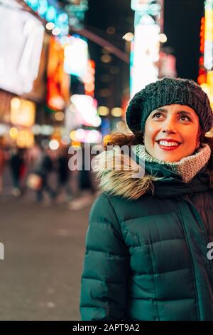 Donna stupita guardando le luci e la folla in Times Square Foto Stock