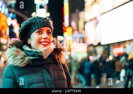 Donna stupita guardando le luci e la folla in Times Square Foto Stock