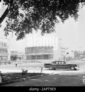 Israele 1964-1965: Tel Aviv, Street images Building, presumibilmente il Teatro Habima Data: 1964 Località: Israele, Tel Aviv Parole Chiave: Automobili, alberi, edifici, ombre Foto Stock