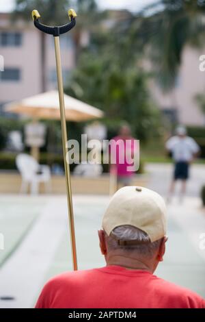 Vista posteriore di un anziano uomo giocando shuffleboard Foto Stock