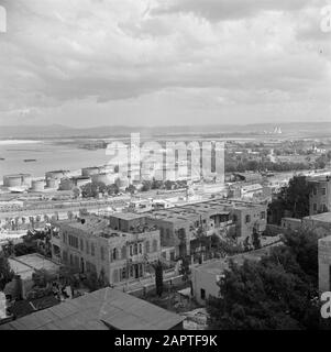 Israele 1948-1949: Haifa Haifa. Città e porto con un cantiere ferroviario e impianti petroliferi e con in primo piano abitazioni uno con terrazza sul tetto Data: 1948 posizione: Haifa, Israele Parole Chiave: Tetti, porti, serbatoi di stoccaggio, panorami, ferrovie, terrazze, case Foto Stock