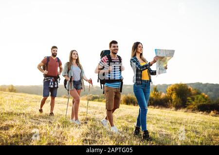 avventura, viaggio, turismo, escursione e concetto di persone - gruppo di amici sorridenti a piedi con zaini in natura Foto Stock