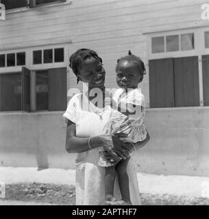 Viaggio nel Suriname e nelle Antille Olandesi La creola boscosa Juliana sul braccio di un'infermiera nativa nell'ospedale 'Principessa Juliana' nella stazione dei cavi Annotazione: Juliana era uno dei gemelli che furono sepolti nella foresta e salvati da sorella Agaath Data: 1947 Località: Stazione via cavo, Suriname Parole Chiave: Foresta di lana, bambini, infermieri Foto Stock