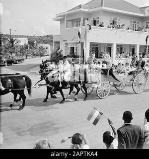 Antille Olandesi e Suriname al momento della visita reale della Regina Juliana e del Principe Bernhard nel 1955 La coppia reale attraversa una strada in Willemstad Annotazione: Il calèche e i cavalli sono stati trasferiti dai Paesi Bassi Data: 18 ottobre 1955 Ubicazione: Curaçao, Antille Olandesi, Willemstad Parole Chiave: carrozze, visite reali, cavalli, immagini di strada, spettatori Foto Stock