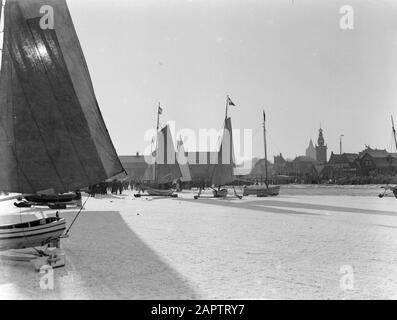 Spret ghiaccio sulle acque ghiacciate nei Paesi Bassi Barche a vela ghiaccio sul Gouwzee con in background la torre della grande chiesa e la torre di gioco di Monnickendam Data: 1931 posizione: Gouwzee, Monnickendam, Nord-Olanda Parole Chiave: Ghiaccio, neve, inverno, navi a vela Foto Stock