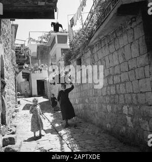 Il villaggio di Peki'in Galilea. Donna con un cesto sulla testa e due bambini in una strada. Rapporto/Serie: Israele - Peki'In; Foto Stock