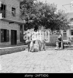 Il villaggio di Peki'in Galilea. Una strada freelance alla fonte locale. Uomini, donne e bambini e un asino. Rapporto/Serie: Israele - Peki'In; Foto Stock